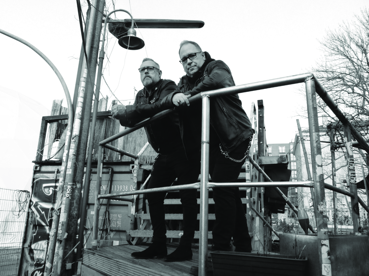 Die beiden Bandmitglieder von Poison Machines stehen am Geländer.